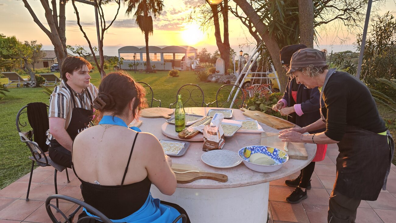 Cena al tramonto durante il corso di cucina calabrese con vista sulle Isole Eolie — Sunset dinner during the Calabrian cooking class overlooking the Aeolian Islands