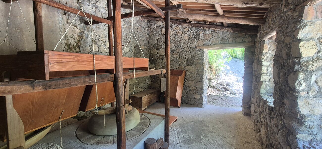 Interno del mulino ad acqua restaurato con le macine in pietra — Inside the restored water mill with its stone grinding wheels