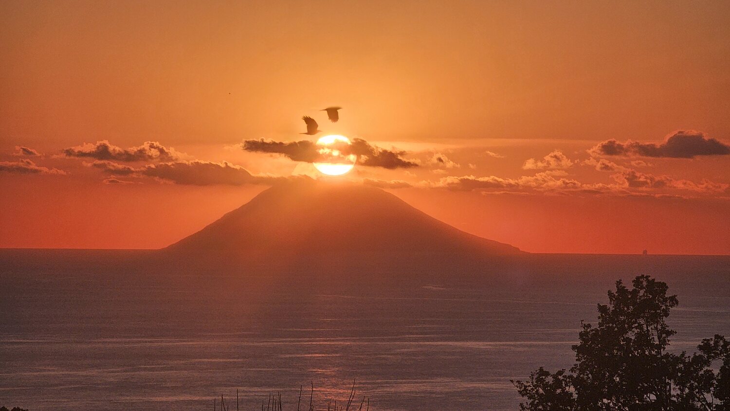 Tramonto spettacolare con il sole che cala dietro il cono dello Stromboli, Isole Eolie — Spectacular sunset with the sun setting behind the cone of Stromboli, Aeolian Islands