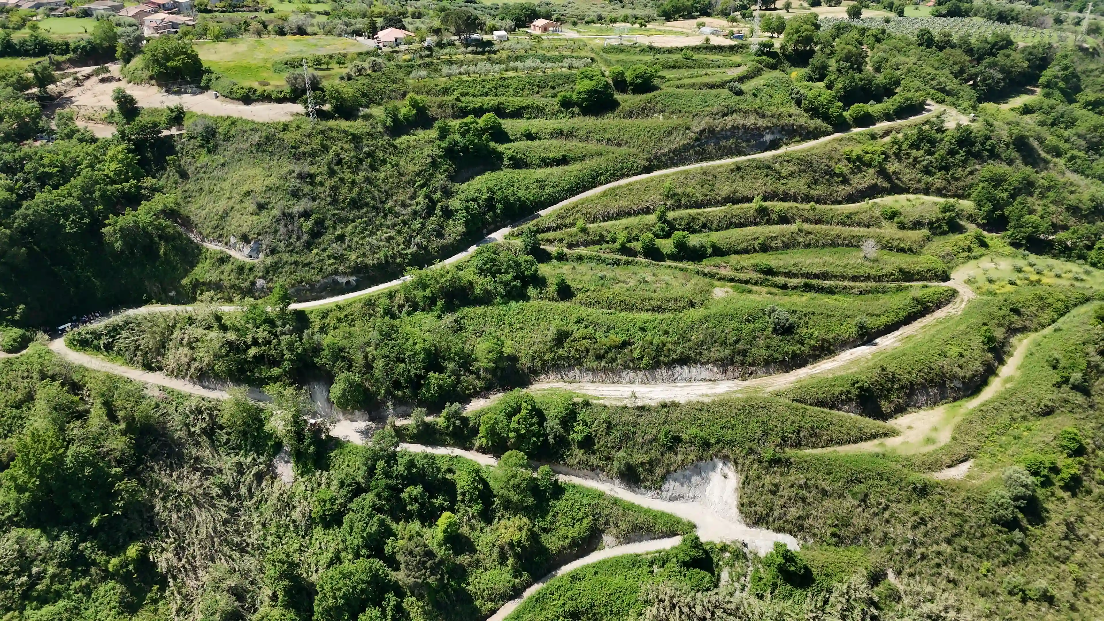 Veduta aerea della Valle della Fiumara Ruffa con il sentiero che attraversa la vegetazione fitta — Aerial view of the Fiumara Ruffa valley with the path crossing dense greenery